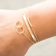 Bracelets en argent sterling pour femme avec duo de cercles entrelacés et plaque gravée fine.