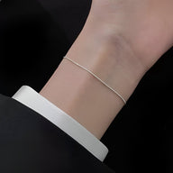 Bracelet fin en argent sterling pour femme porté au poignet, style minimaliste et élégant.