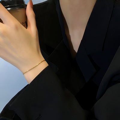 Bracelet fin en argent sterling délicatement posé au poignet, style minimaliste élégant.