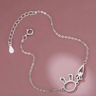 Bracelet en argent sterling fin avec pendentifs lapin et carotte délicats, fermoir anneau ressort.