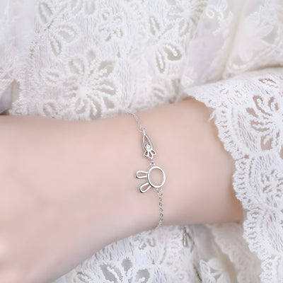 Bracelet en argent sterling avec pendentif lapin et carotte délicat porté sur poignet féminin en dentelle blanche.