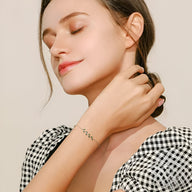 Bracelet en argent sterling avec motif feuille délicate, porté par une femme au teint clair et cheveux attachés, style.