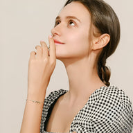 Bracelet en argent sterling avec petits motifs feuilles scintillantes porté au poignet féminin.