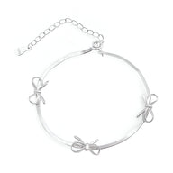 Bracelet en argent sterling pour femme avec trois noeuds ruban délicats et chaîne ajustable.