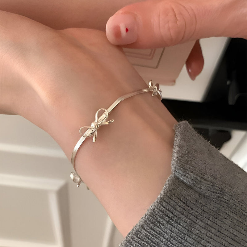 Bracelet en argent sterling fin avec motif noeud ruban délicat, élégant et minimaliste.