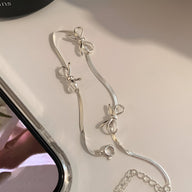 Bracelet en argent sterling fin avec trois noeuds ruban délicats, fermoir mousqueton.