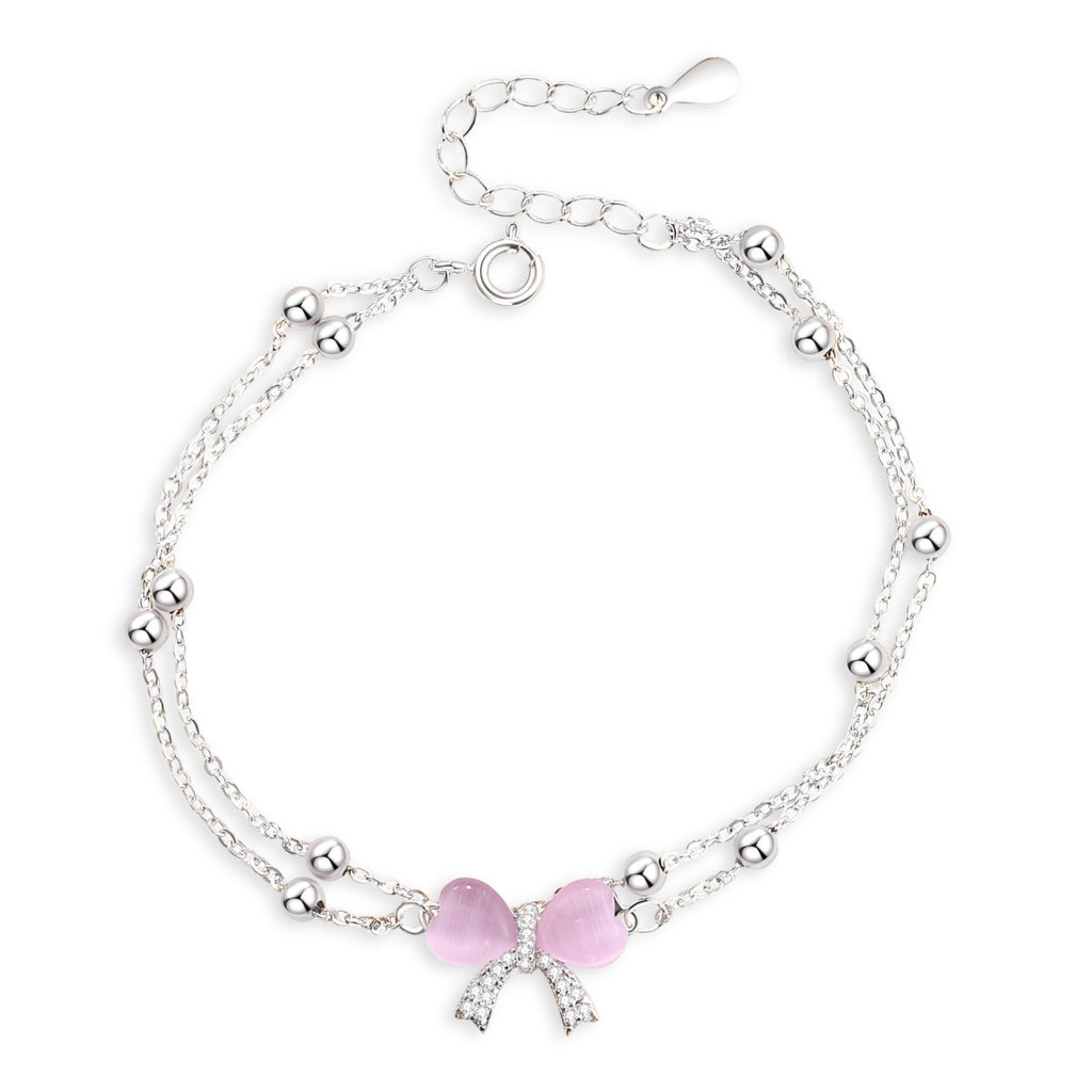 Bracelet en argent sterling avec double chaîne et noeud ruban rose orné de petits cristaux.