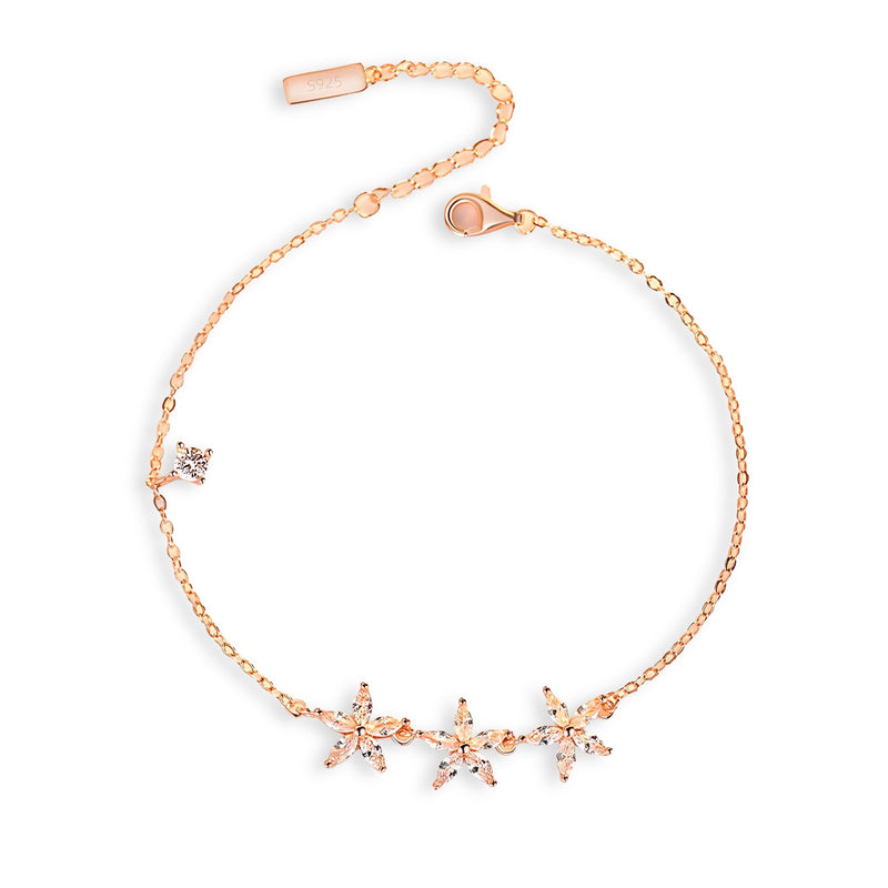 Bracelet fin en or rosé avec trois étoiles délicates serties de pierres brillantes.