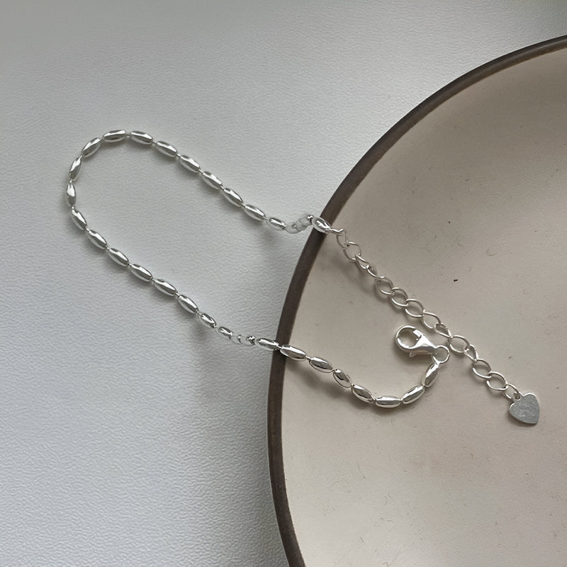 Bracelet en argent sterling style grain de riz avec pendentif cœur et chaîne réglable.