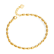 Bracelet femme en or à maillons grain de riz avec fermoir mousqueton et chaîne de réglage.