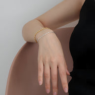 Bracelet grain de riz en argent sterling fin porté au poignet, design élégant et délicat.