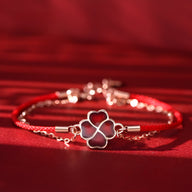 Bracelet en argent sterling avec trèfle à 4 feuilles changeant de couleur sur cordon rouge fin.