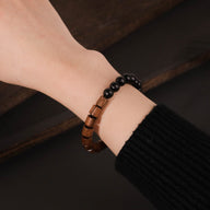 Bracelet mixte en perles de bois de palissandre marron et d'ébène noir, style naturel et élégant.