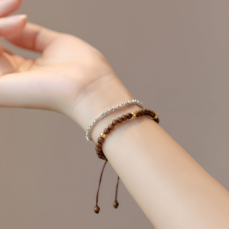 Bracelet femme en bois de santal marron avec cordon réglable et perles lisses.