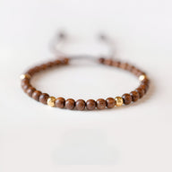 Bracelet en bois de santal marron avec perles dorées, design raffiné et naturel pour femme.