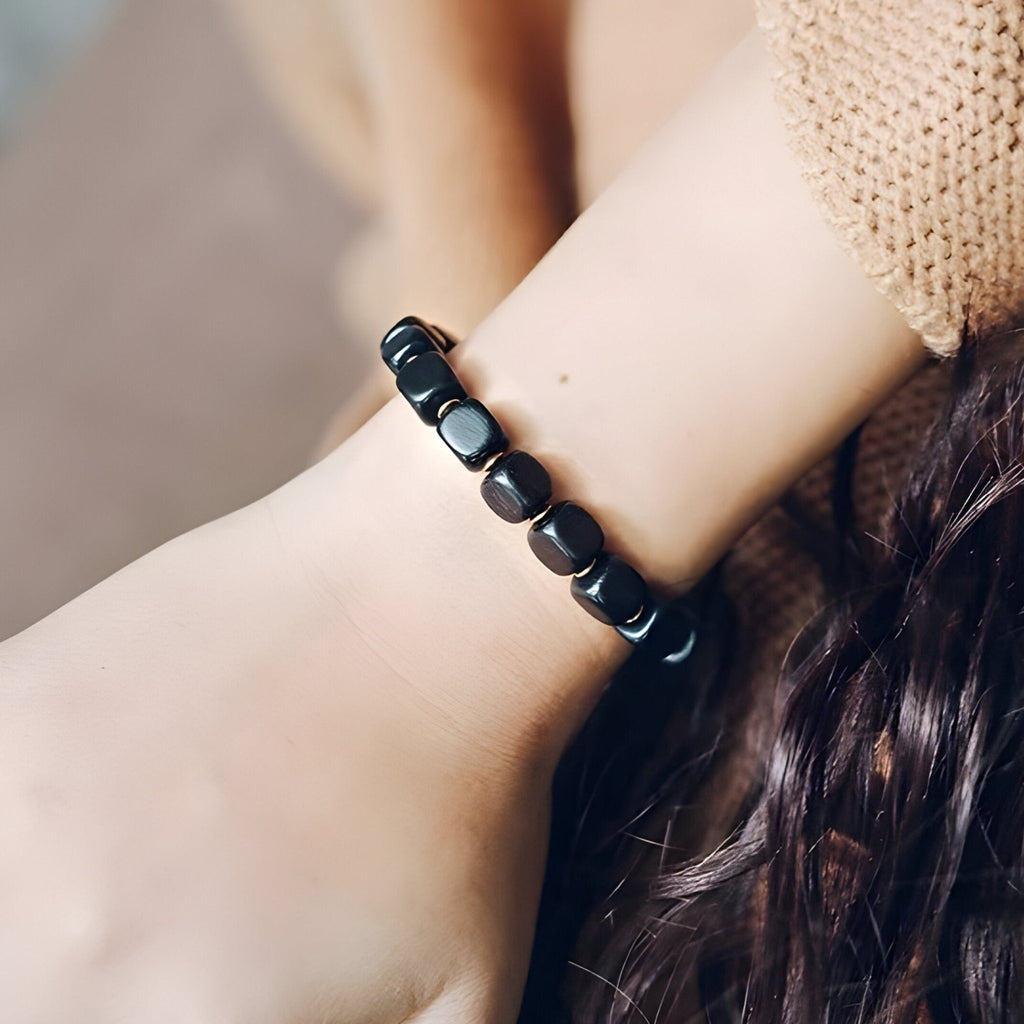 Bracelet femme en bois d'ébène noir avec perles aux détails antiques, style élégant et naturel.