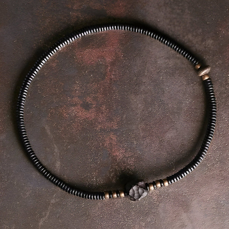 Bracelet femme en perles noires d’ébène et détails en cuivre avec nœud ajustable.
