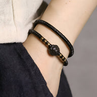 Bracelets noirs en bois d'ébène et cuivre, style perles lisses et facettées, ajustables pour femme.