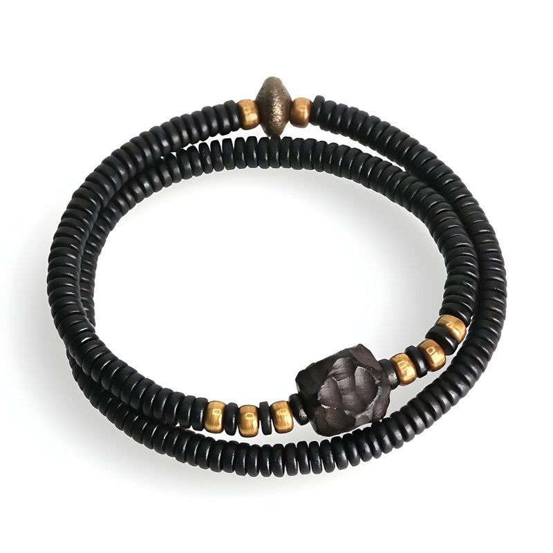 Bracelet double tour en perles de bois d'ébène noir avec détails en cuivre et perle centrale sculptée.