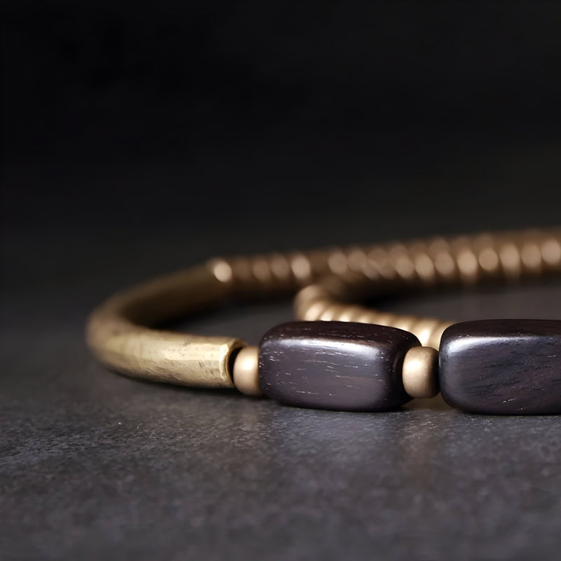 Bracelet femme en bois d'ébène noir avec perles cylindriques en cuivre patiné.