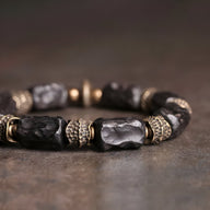 Bracelet mixte en bois d'ébène noir sculpté avec anneaux en laiton texturé, style unique.