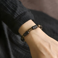 Bracelet mixte en bois d'ébène noir avec éléments en laiton, design élégant et naturel.