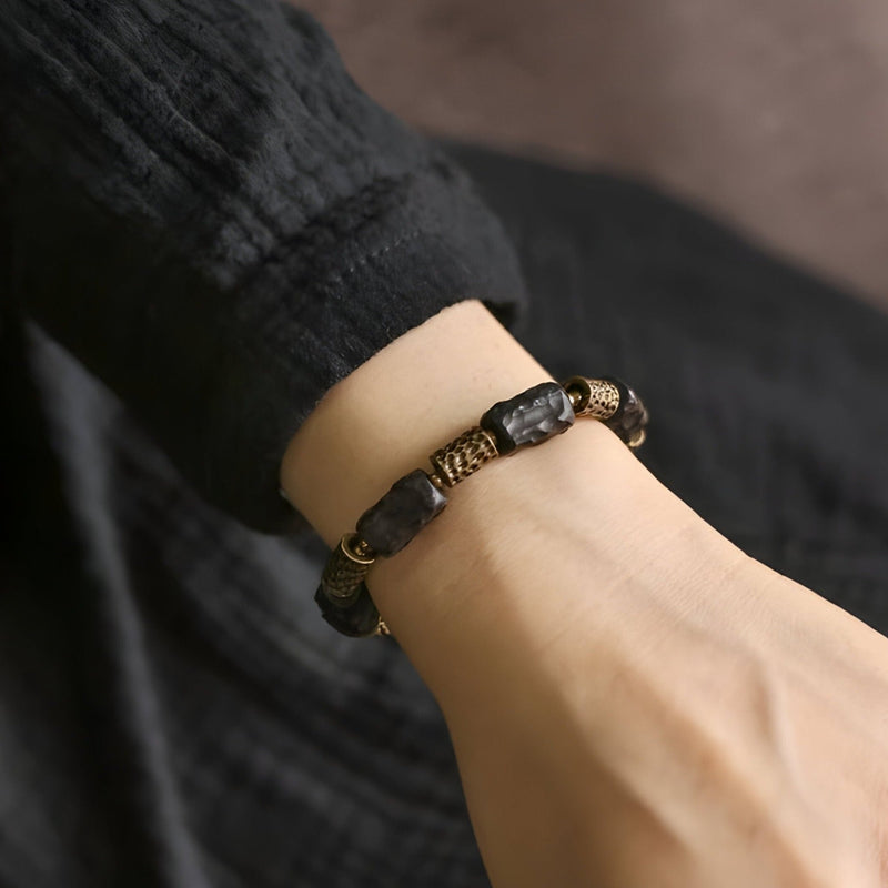 Bracelet mixte en bois d'ébène noir avec éléments en laiton, design élégant et naturel.