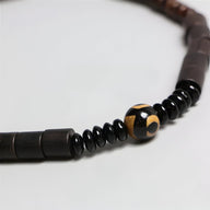 Bracelet mixte en bois d’ébène noir avec perle centrale en obsidienne noire et jaune, style naturel.