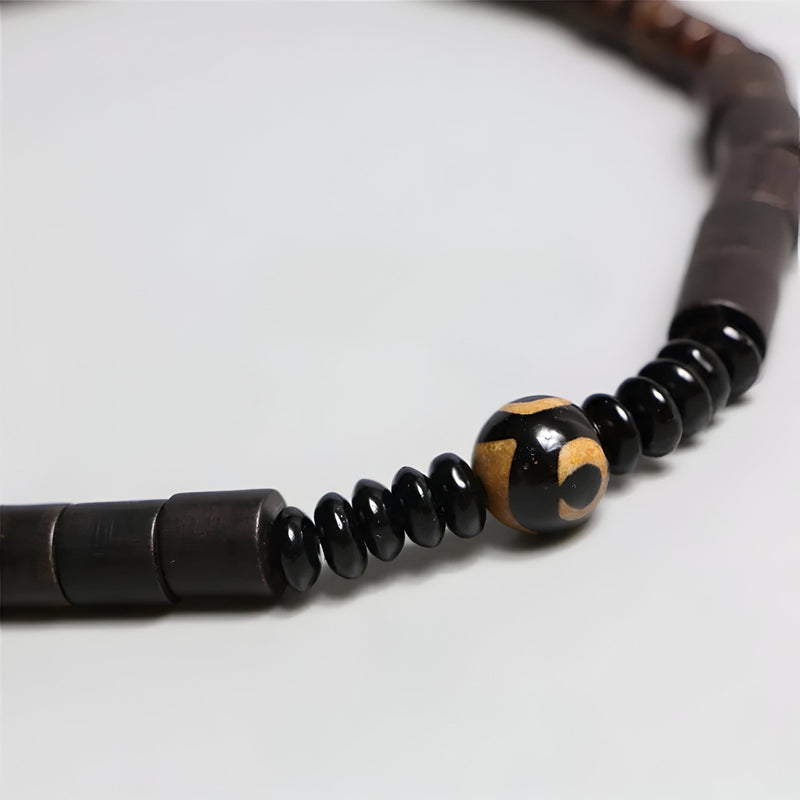 Bracelet mixte en bois d’ébène noir avec perle centrale en obsidienne noire et jaune, style naturel.