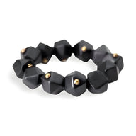 Bracelet femme en bois d'ébène noir mat avec formes géométriques et petits clous dorés.