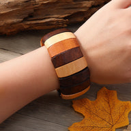 Bracelet large en bois naturel multicolore avec bandes marron, beige et caramel, style artisanal pour femme.