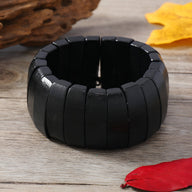 Bracelet large en bois noir naturel aux segments lisses et finition mate pour femme.