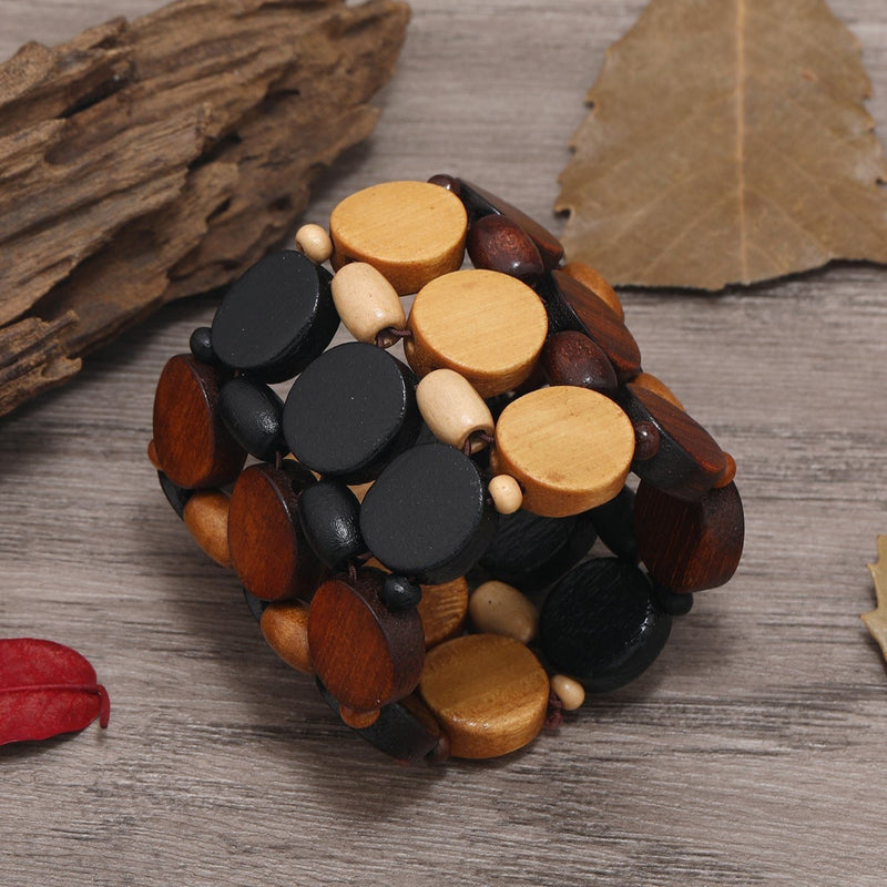 Bracelet large en bois naturel multicolore avec perles rondes dans tons marron, noir et beige.