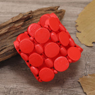 Bracelet femme en bois naturel rouge avec boutons ronds et couture apparente rouge.