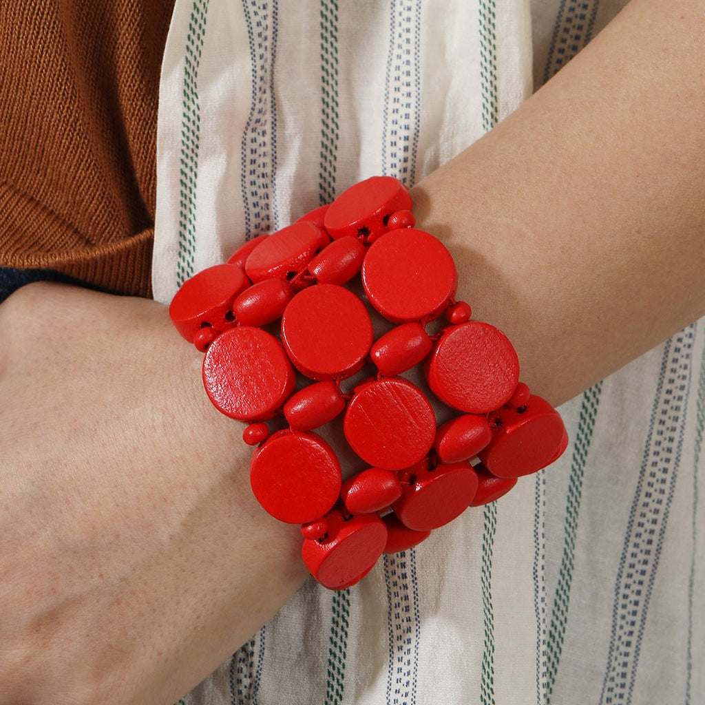 Bracelet large en bois naturel rouge avec disques ronds lisses, style original pour femme.