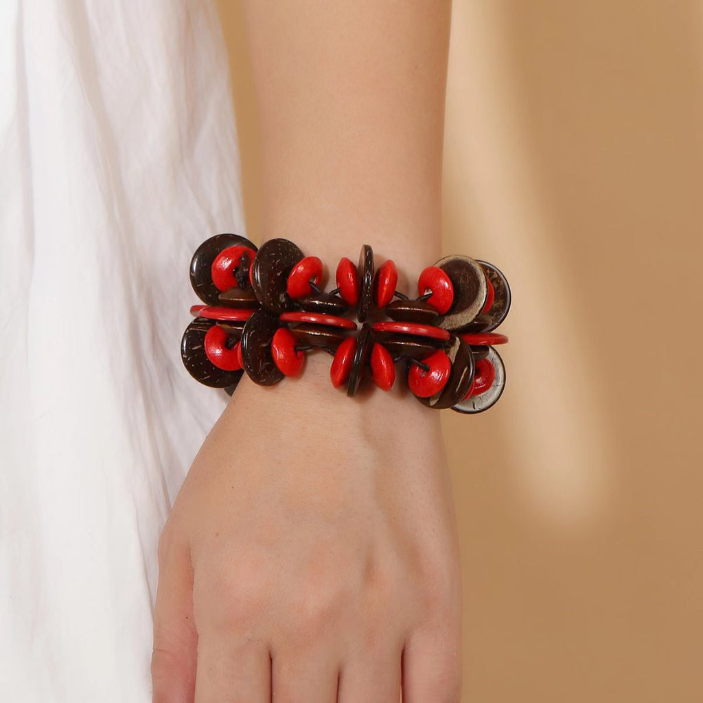 Bracelet femme en bois naturel avec perles rouges et café, style audacieux et structuré.