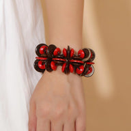 Bracelet femme en bois naturel avec perles rouges et café, style audacieux et structuré.