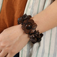 Bracelet en bois café foncé avec fleurs sculptées et grosses perles, style naturel pour femme.