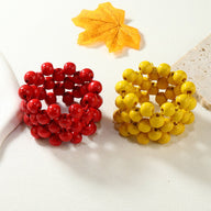 Bracelet femme en bois naturel avec multiples perles rouges et bracelet jaune aux perles rondes.