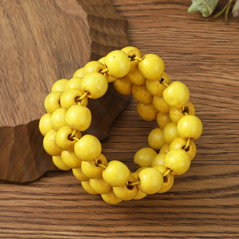Bracelet femme en perles de bois naturel jaunes, style multiple rangs tressés.