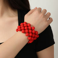 Bracelet femme en perles bois rouge vif, style multiple rangs, tenue ajustée poignet.
