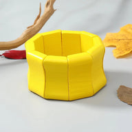 Bracelet large en bois naturel peint jaune solaire avec segments arrondis et finition lisse.