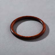 Bracelet jonc fin en bois naturel marron avec finition lisse et brillante.