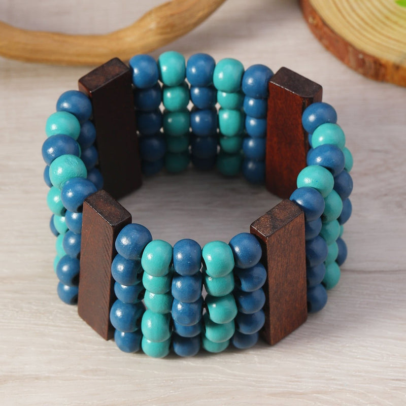 Bracelet manchette femme en perles de bois bleu et éléments rectangulaires en bois foncé.