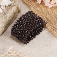 Bracelet en bois naturel café avec motifs floraux sculptés, style large et texturé pour femme.