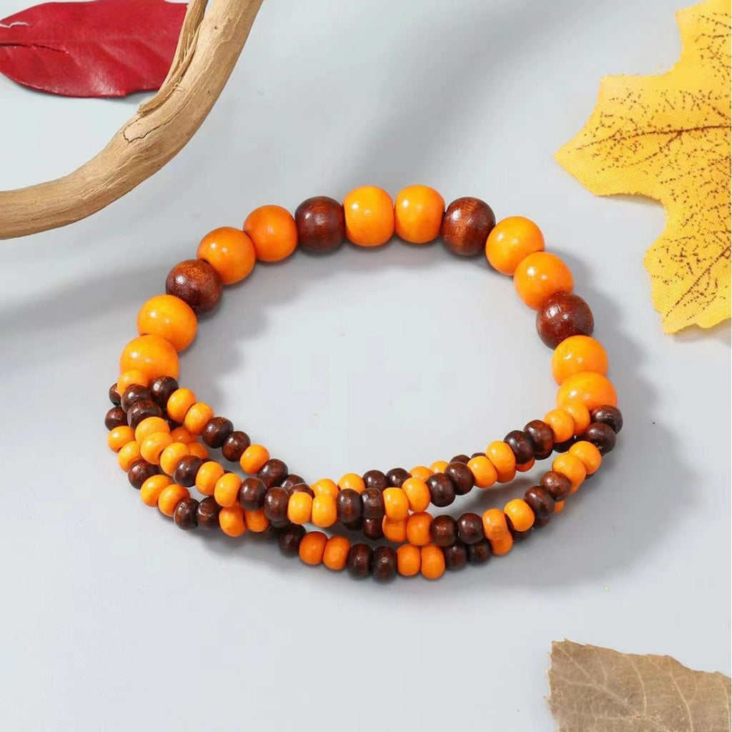 Bracelet femme en perles bois orange et marron, design multi-rangs naturel et brillant.