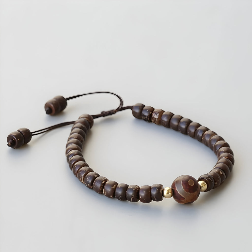 Bracelet marron ajustable en coquille de noix de coco avec perles d'agate marron et détails dorés.