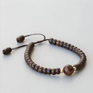 Bracelet marron ajustable en coquille de noix de coco avec perles d'agate marron et détails dorés.