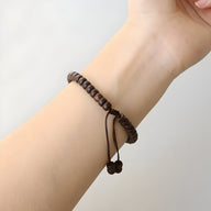 Bracelet marron en coquilles de noix de coco et pierre d'agate, modèle ajustable avec cordelette nouée.