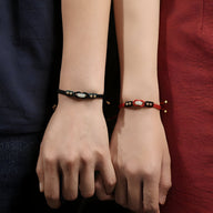 Bracelet tressé noir avec perle de jade verte et détails dorés, modèle River.